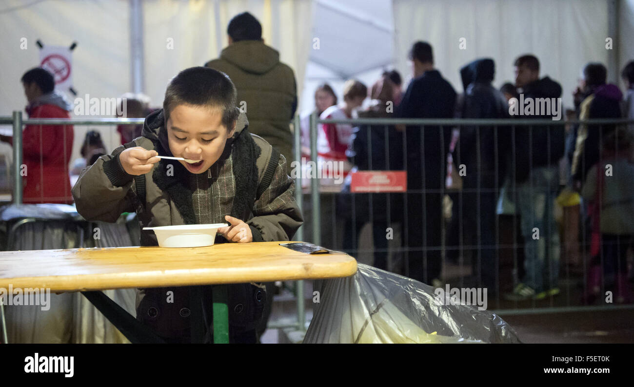 Hängend, Österreich. 2. November 2015. Ein Flüchtlingskind aus Afghanistan seinen Teller Suppe als Flüchtlingsfamilien Weitertransport nach Deutschland in einem Notfall Zelt in der Nähe von hängenden, Österreich, 2. November 2015 warten. Seit einiger Zeit benutze ankommenden Flüchtlinge aus verschiedenen Ländern den deutsch-österreichischen Grenzübergang zwischen hängenden und Wegscheid auf ihrem Weg von Österreich nach Deutschland. Foto: Peter Kneffel/Dpa/Alamy Live News Stockfoto