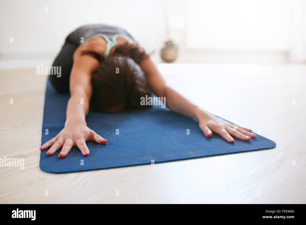 Frau tut stretching Workout im Fitness-Matte. Gymnastikmatte in Turnhalle weiblichen Ausführenden Yoga aufstecken. Kind-Pose, Balasana. Stockfoto