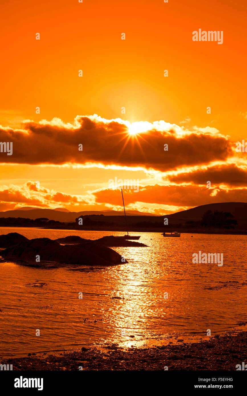 Boote in einer ruhigen Bucht in der Nähe von Kenmare am Wilden Atlantik Way Irland mit einer orange Sunset Stockfoto