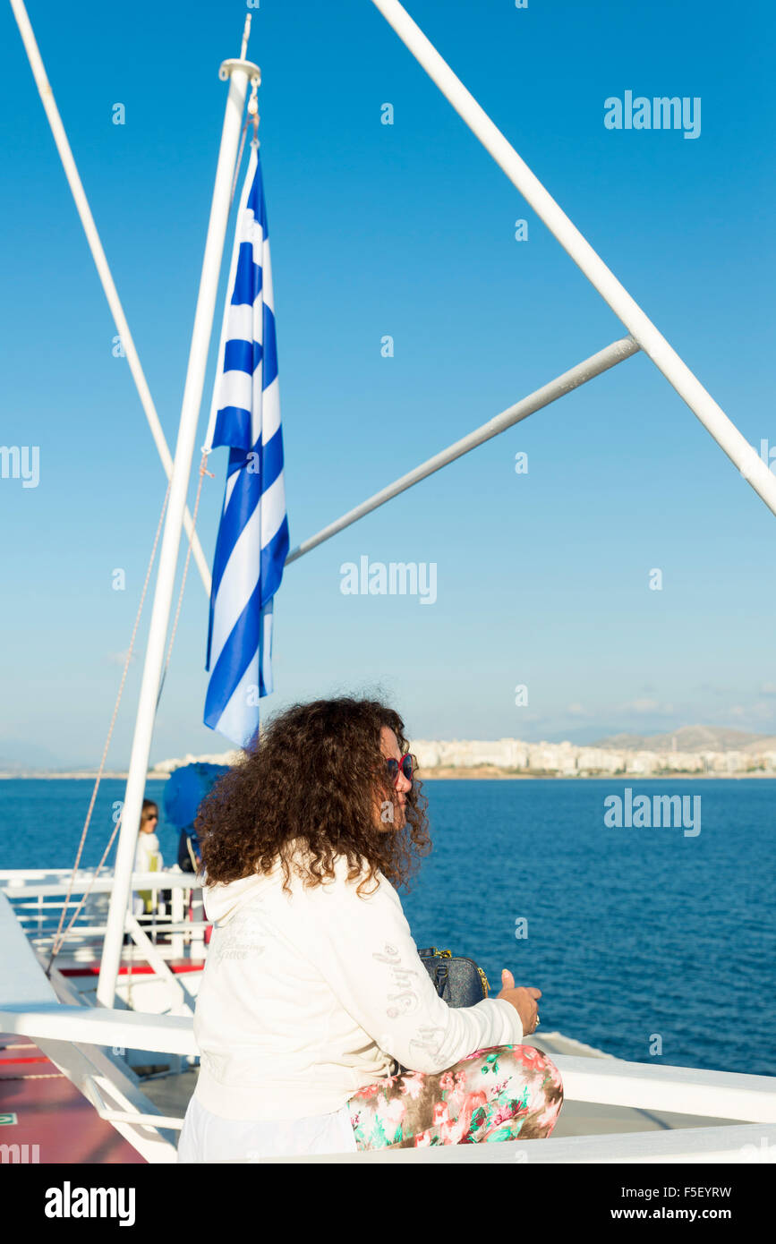 Ägäis, Griechenland - 25. Oktober 2015: Eine junge Frau sieht, die Stadt Athen vom Heck eines Bootes Stockfoto