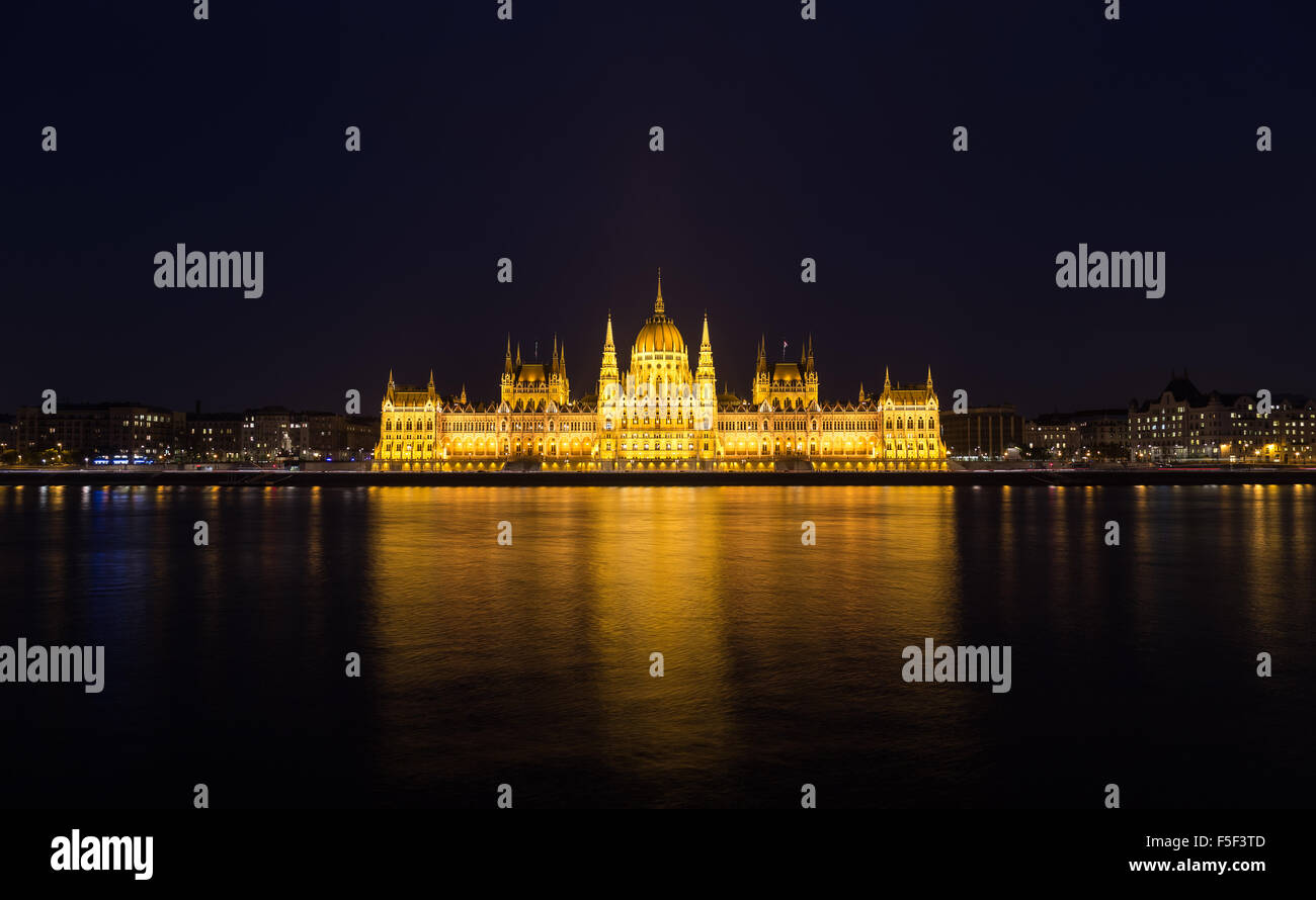 Ein Blick auf das ungarische Parlamentsgebäude an der Donau in der Nacht mit dem Bau beleuchtet und Reflexionen in der wate Stockfoto