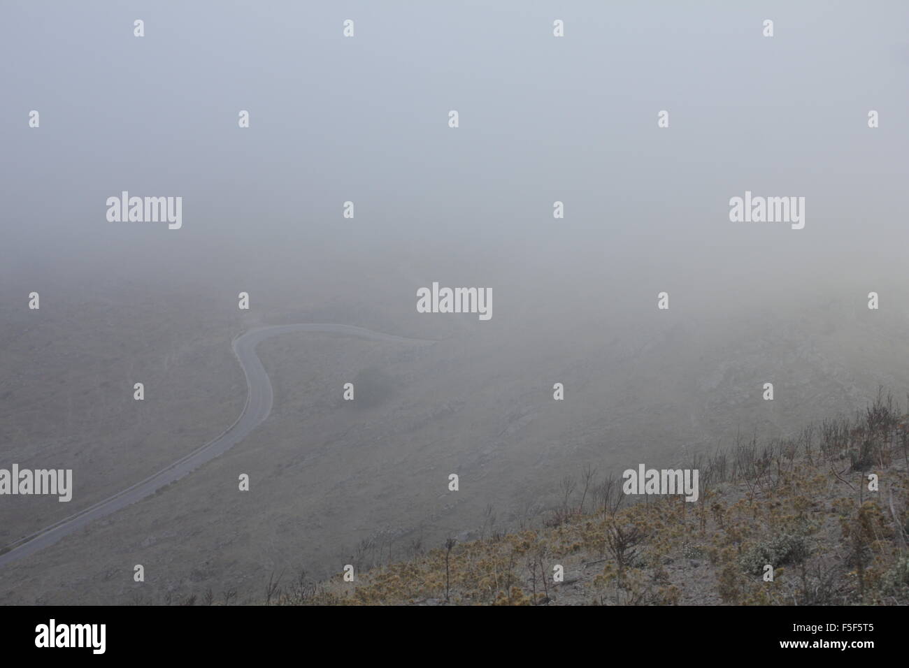 Die Ländlichen "geschwungene Straße in Schicht Nebel/hoher Luftfeuchtigkeit abgedeckt. Platy Dorf, Limnos, Griechenland Stockfoto