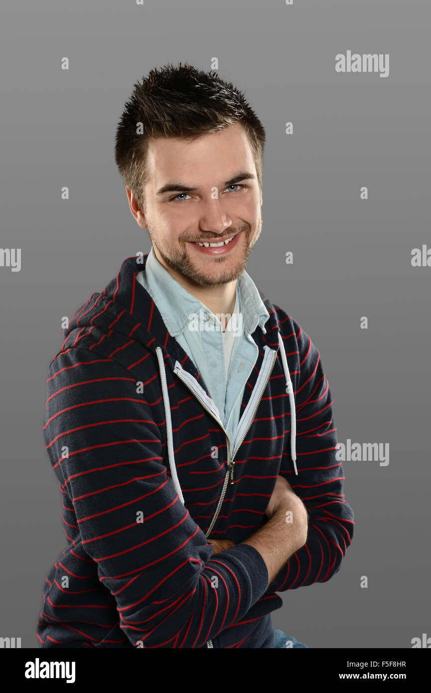 Porträt des jungen Mann lächelnd über grauen Hintergrund isoliert Stockfoto