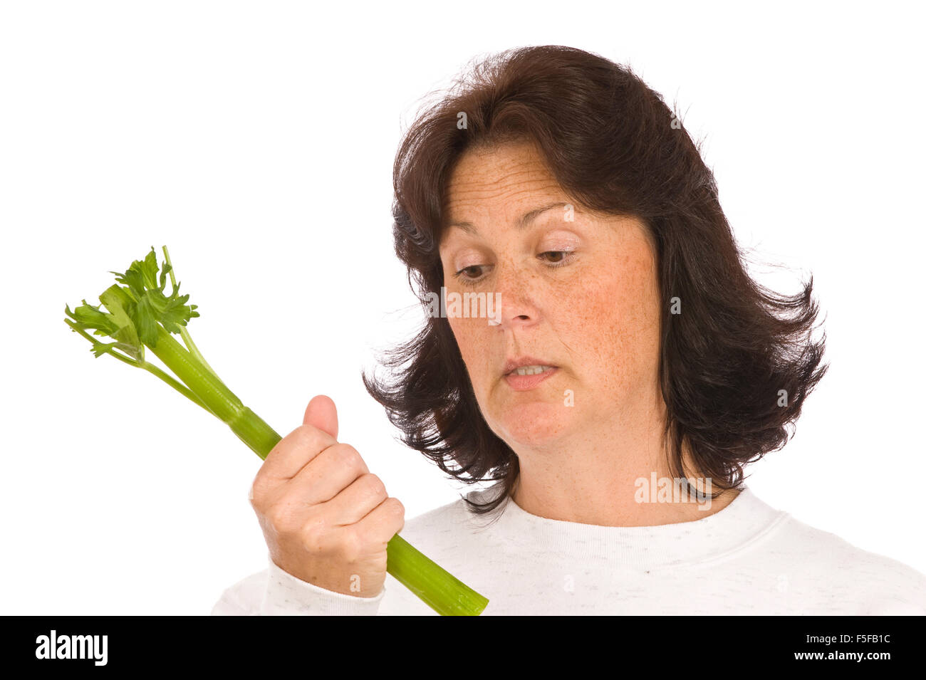 Eine Frau hält einen Stiel von Sellerie ab ihrer Diät denkt: Ich kann Do This Stockfoto