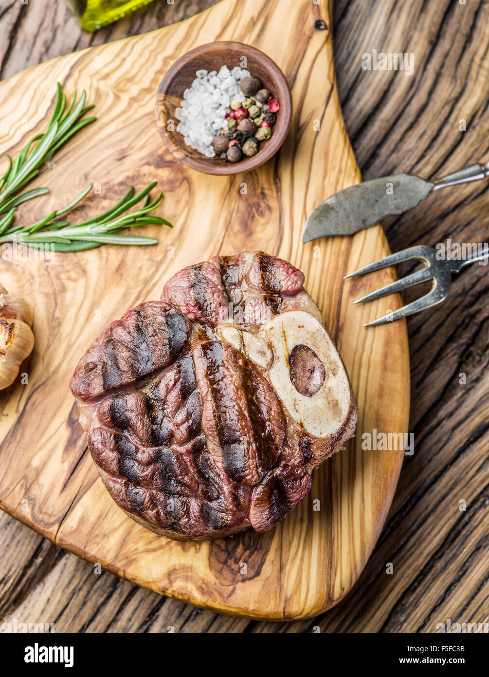 Rindersteaks mit Gewürzen auf einem Holztablett. Stockfoto