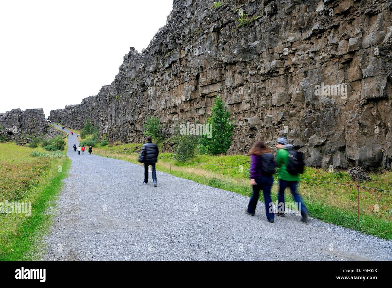 Menschen auf der Spur von vulkanischen Felswänden (eurasischen und nordamerikanischen tektonische Platten kollidieren), Nationalpark Thingvellir, Island Stockfoto