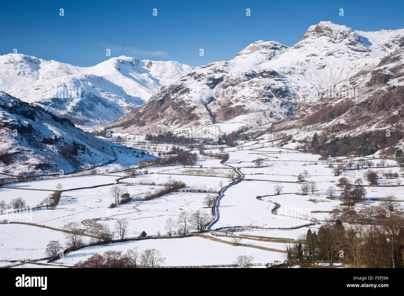 Blick auf Langdale und Langdale Pikes in The Lake District National Park, UK, an einem herrlichen sonnigen Tag nach einer durchzechten Nacht Schnee. Stockfoto