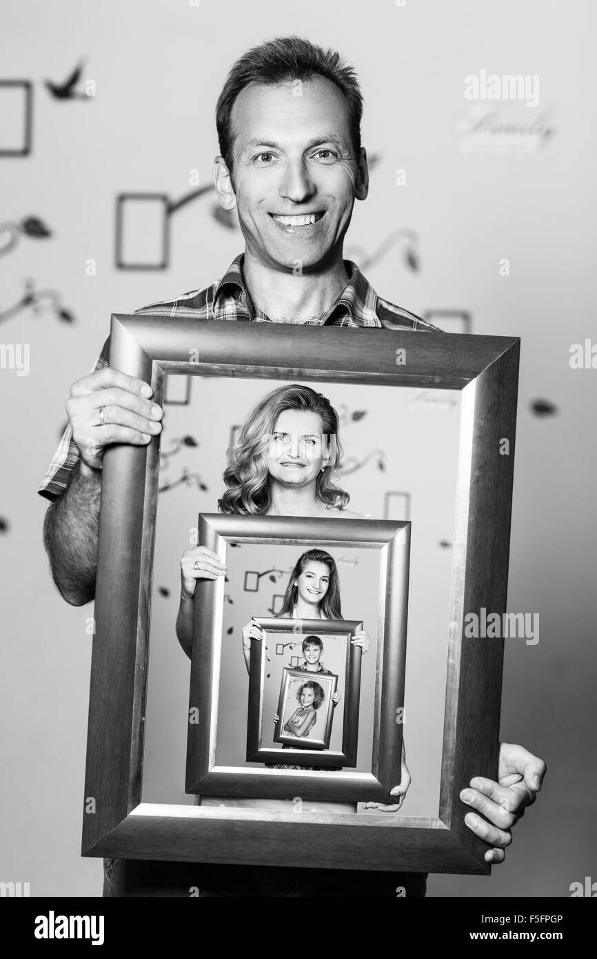 Glücklicher Vater hält Porträt mit seiner Familie Stockfoto