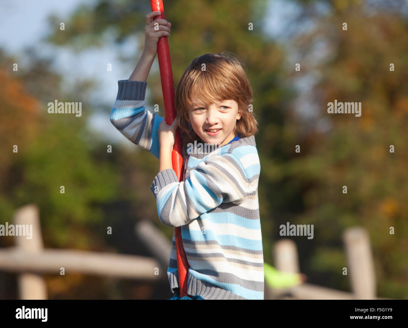 Junge auf einer Schaukel auf dem Spielplatz Stockfoto