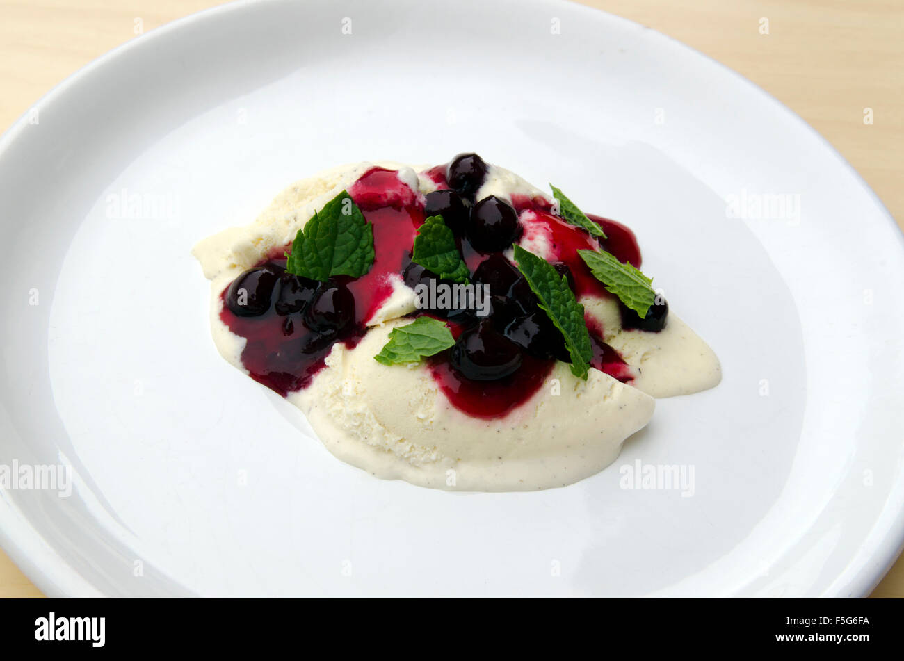 Gutes Dessert mit Vanille-Eis und Aronia Marmelade mit Zitronenmelisse auf Topp, Bild aus Nordschweden. Stockfoto