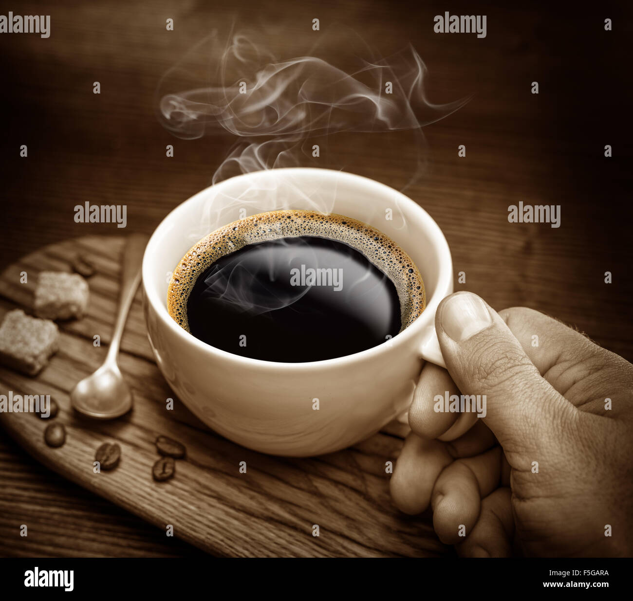 Tasse Kaffee und Rohrzucker Würfel auf Holztisch. Stockfoto