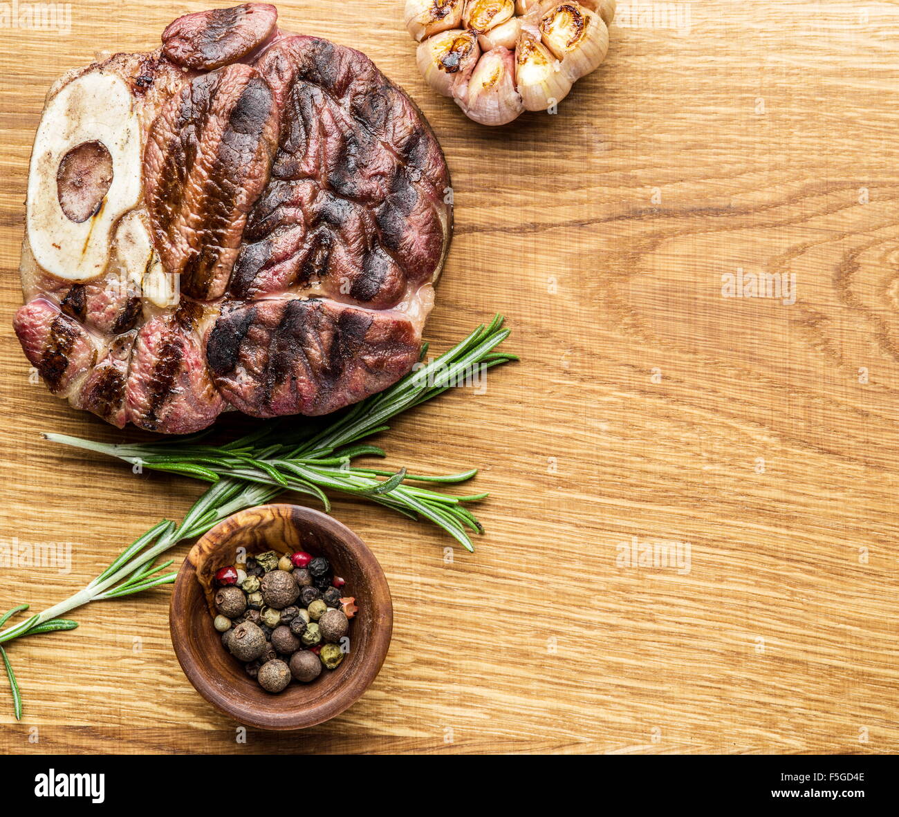 Rindersteaks mit Gewürzen auf einem Holztablett. Stockfoto