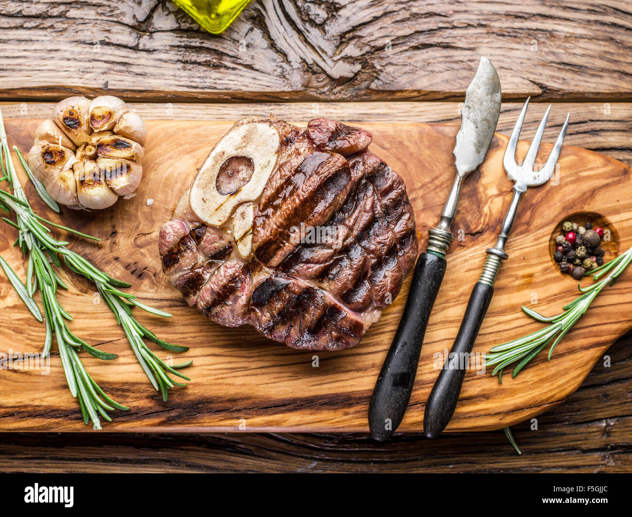 Rindersteaks mit Gewürzen auf einem Holztablett. Stockfoto