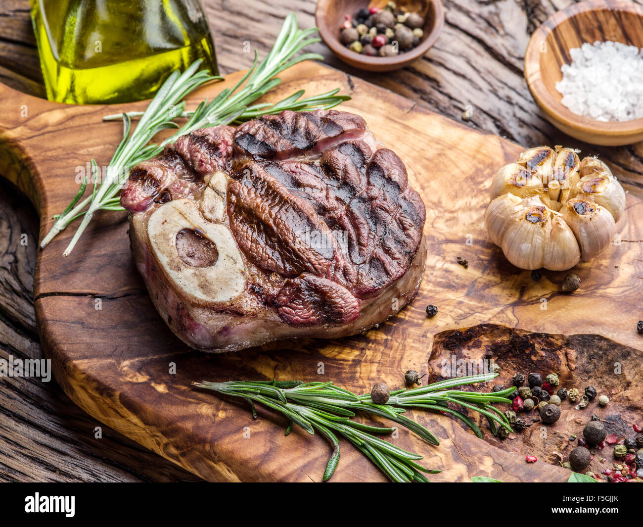 Rindersteaks mit Gewürzen auf einem Holztablett. Stockfoto
