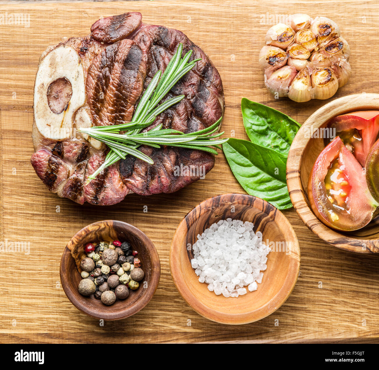 Rindersteaks mit Gewürzen auf einem Holztablett. Stockfoto