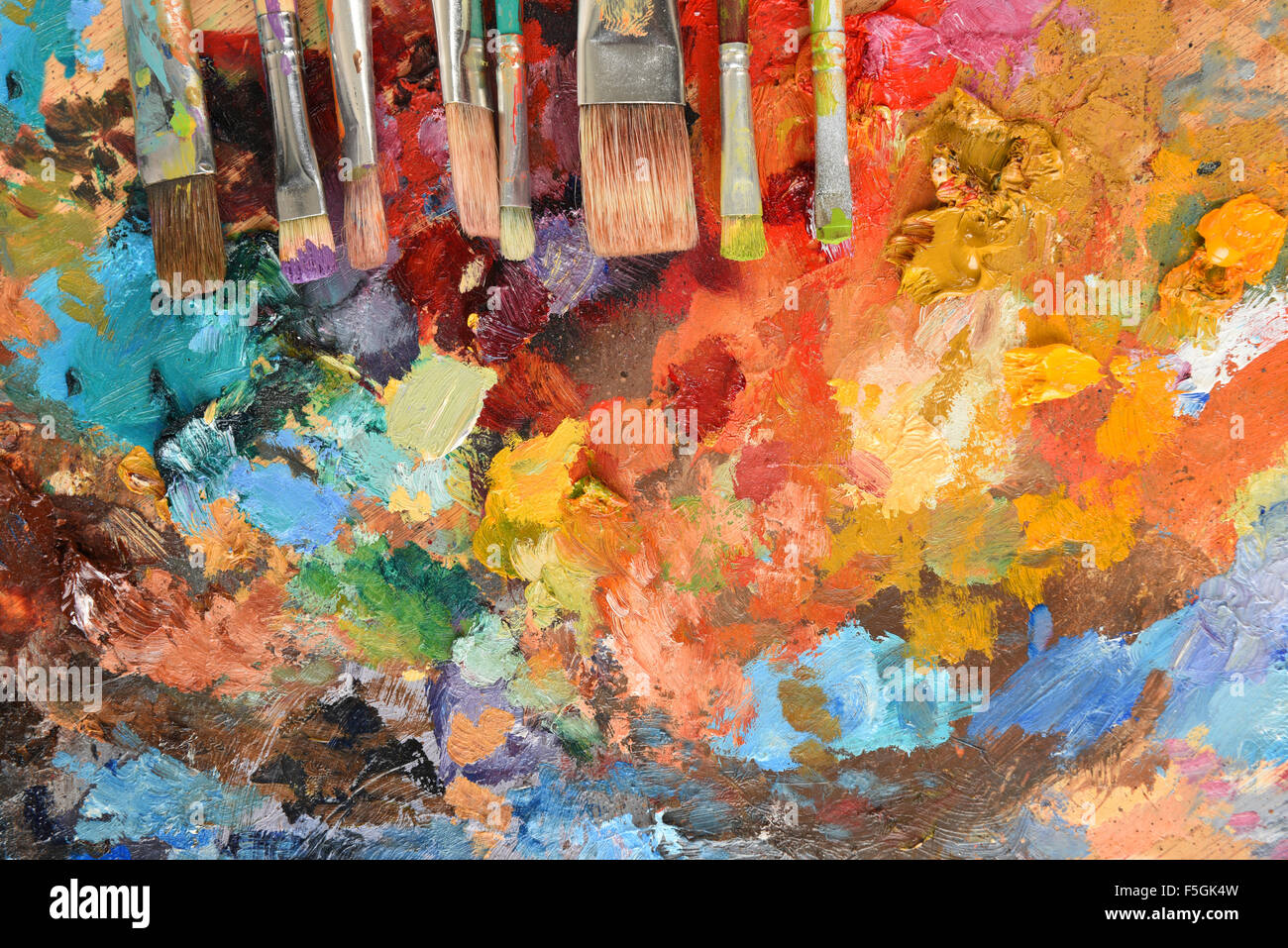 Des Künstlers Pinsel auf Palette mit verschiedenen Ölfarben Stockfoto