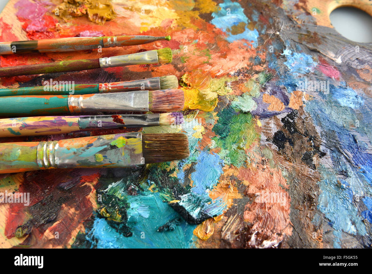 Künstler-Pinsel auf Palette mit mehreren Farben Stockfoto