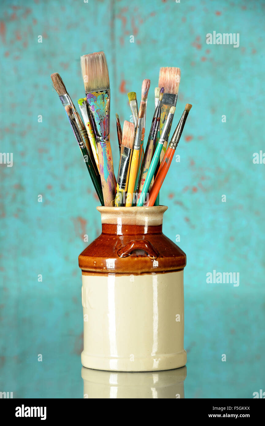 Künstler-Pinsel in einem Glas über farbigen Hintergrund Stockfoto