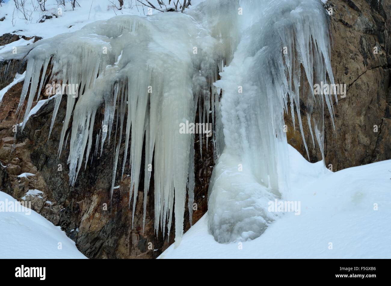 massive Eis und Eiszapfen hängen von einem großen Felsen-Seite auf dem Berg Kaperdalen in Nord-Norwegen Stockfoto