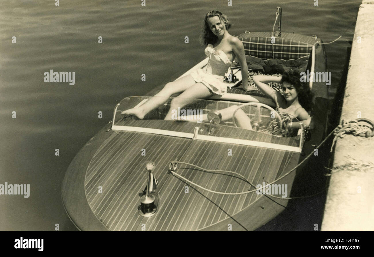 Zwei Mädchen in Kostümen auf einer Holzmotorboot geben Sie Riva, Italien Stockfoto