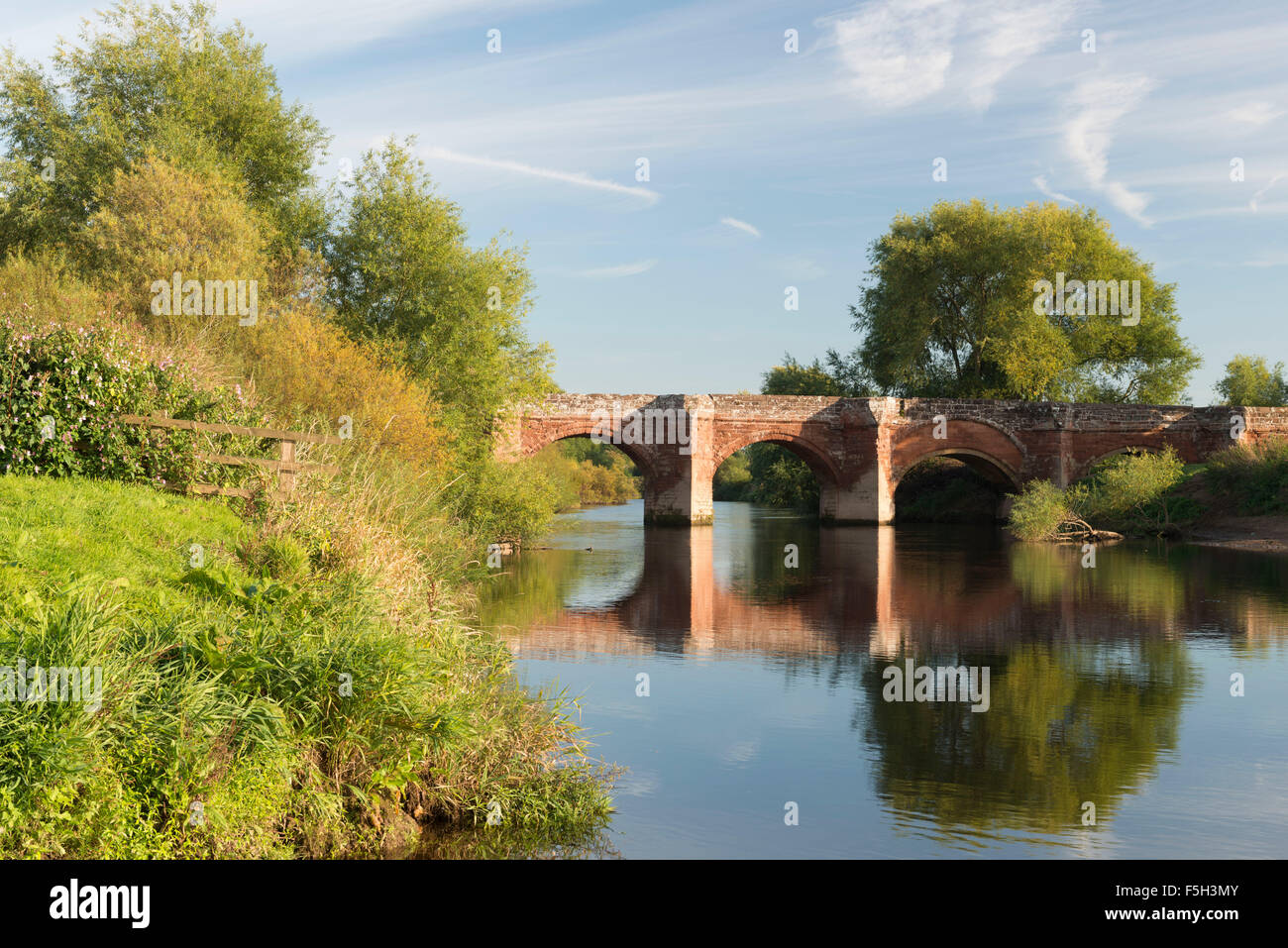 Die mittelalterliche Sandstein-Brücke überquert den Fluss Dee zwischen England und Wales am Farndon Stockfoto