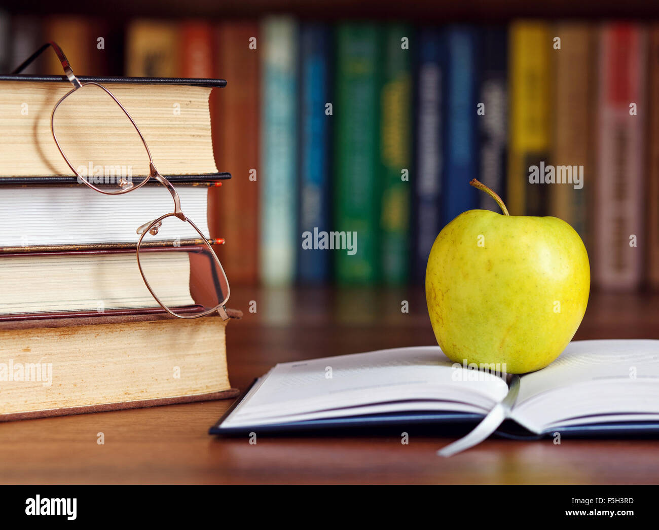 Apfel auf das aufgeschlagene Buch Stockfoto