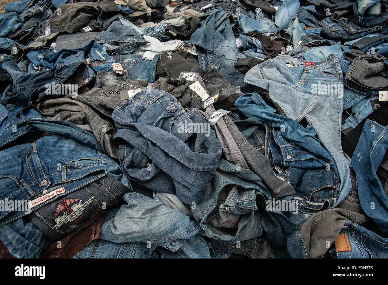 Gebrauchte Jeans zu verkaufen, werden übereinander gestapelt vor einem  Stall in Little India, Singapur Stockfotografie - Alamy
