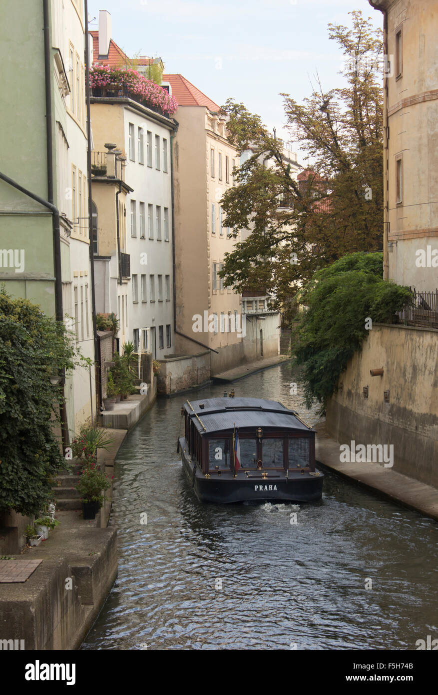 Kanalboot schlängelt sich durch einen engen Kanal im Stadtzentrum von Prag.  Prag, Tschechische Republik. Stockfoto