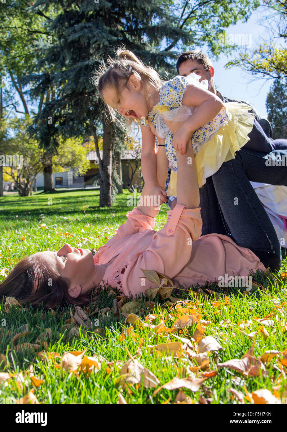 Schöne Mutter spielen auf Rasen mit niedlichen kleinen Tochter, Stadtpark Stockfoto