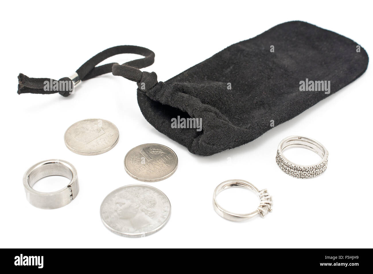 Schwarzer samt Beutel mit Münzen auf weiß und Silber-Ringe Stockfoto