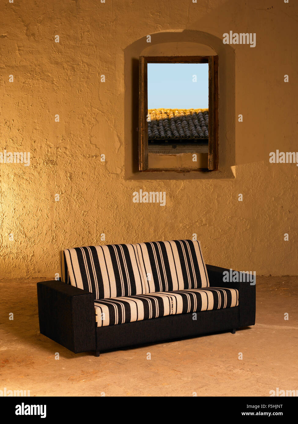 Sofa in einem großen leeren Innenraum mit offenen Fenster vertikal Stockfoto