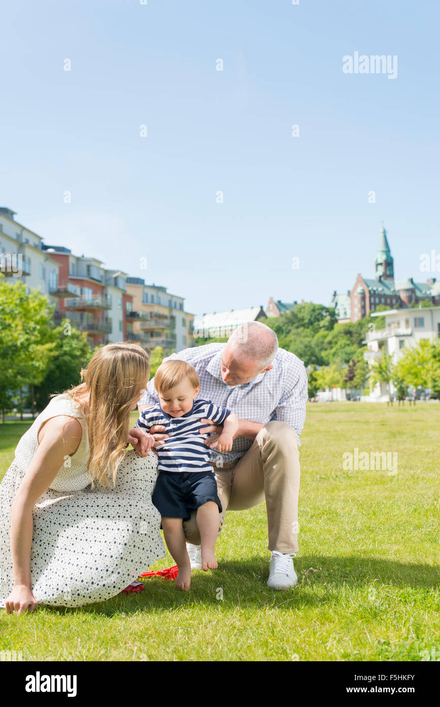 Schweden, Sodermanland, Nacka, Finnboda Hamnøya Eltern Sohn (18-23 Monate) mit ersten Schritten zu unterstützen Stockfoto