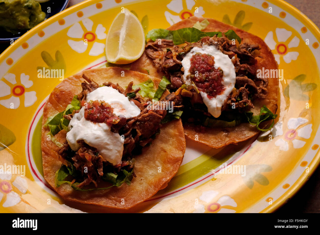 Ein Gericht aus Carnitas Tostada gebraten eine flache Tortilla serviert mit Hackfleisch Stockfoto