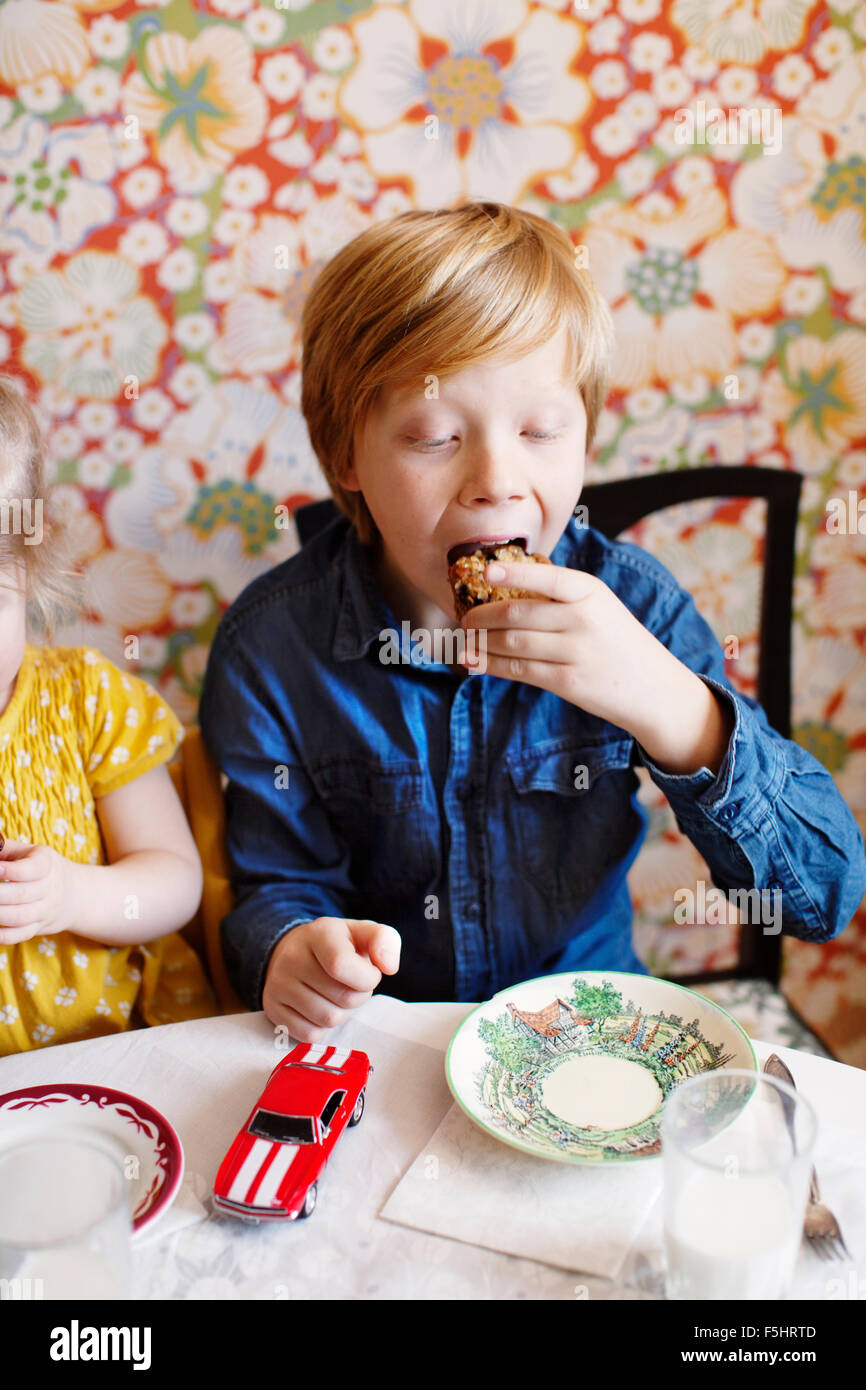 Schweden, junge (10-11) und Mädchen (2-3) essen Kuchen Stockfoto
