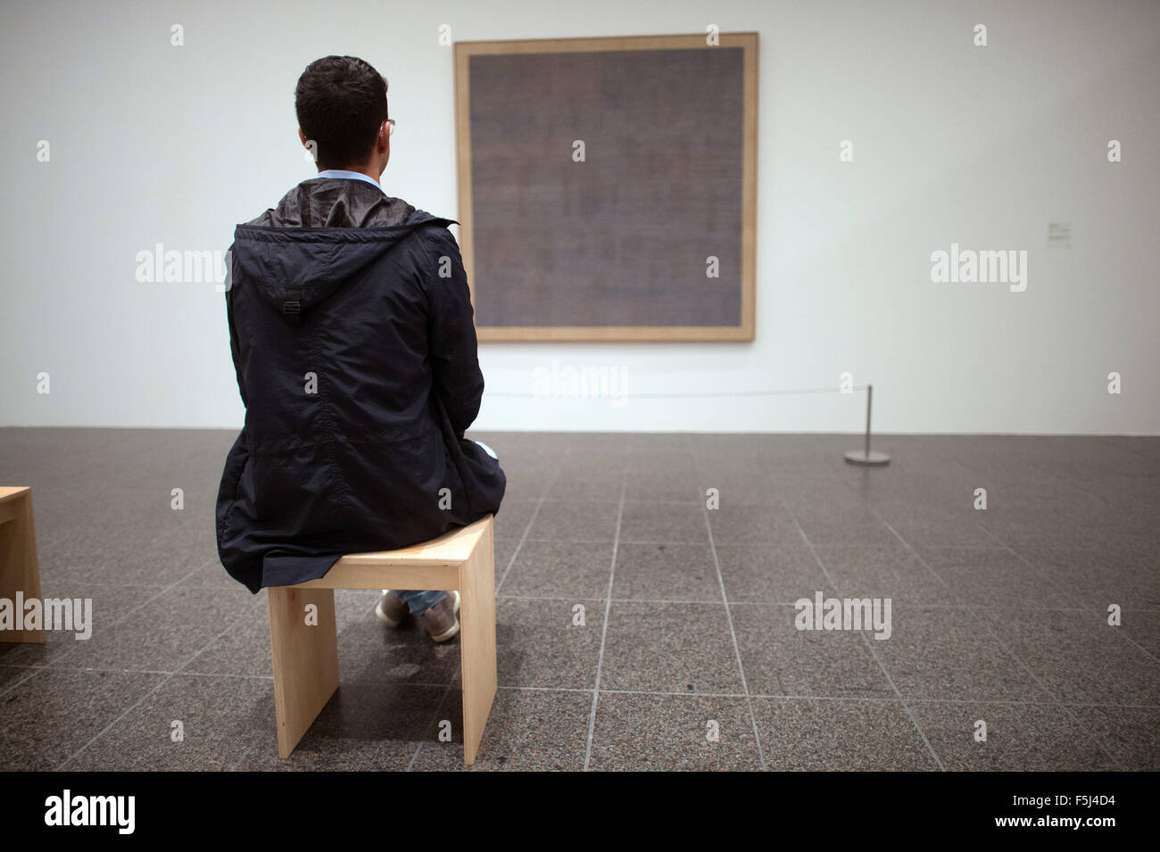 Düsseldorf, Deutschland. 5. November 2015. Ein Besucher schaut das Bild "Falling Blue" aus dem Jahr 1963 von Agnes Martin in der Kunstsammlung Nordrhein-Westfalen in Düsseldorf, Deutschland, 5. November 2015. Die Retrospektive "Agnes Martin" - mit 130 Gemälde, Zeichnungen und Drucke - ersichtlich in der Kunstsammlung Nordrhein-Westfalen vom 7. November 2015 bis 6. März 2016. Foto: FEDERICO GAMBARINI/Dpa/Alamy Live News Stockfoto