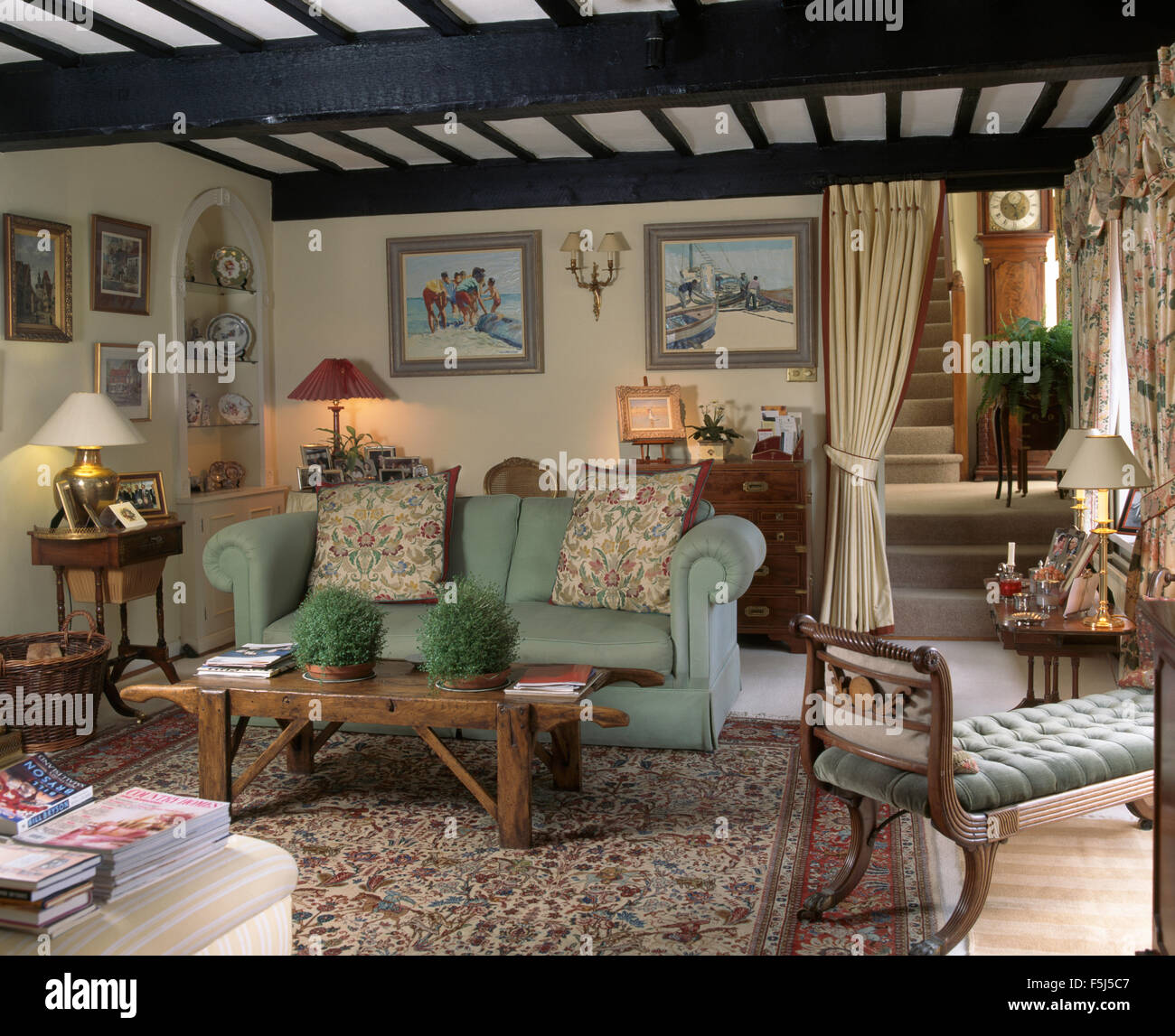 Blasses Grün Sofa und eine ungewöhnliche rustikal Couchtisch aus Holz mit  Griffen in einer neunziger Jahre Ferienhaus Wohnzimmer Stockfotografie -  Alamy