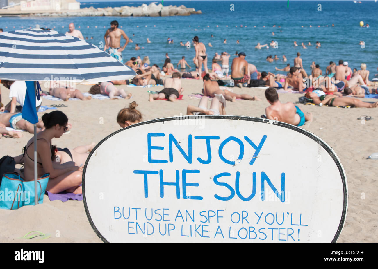 Warnung vor Sonnenbrand, mit Sonnencreme, UV, Gefahren, nicht schlafen am Strand von Barceloneta Strand, Stadtstrand Barcelona, Katalonien, Spanien. Stockfoto