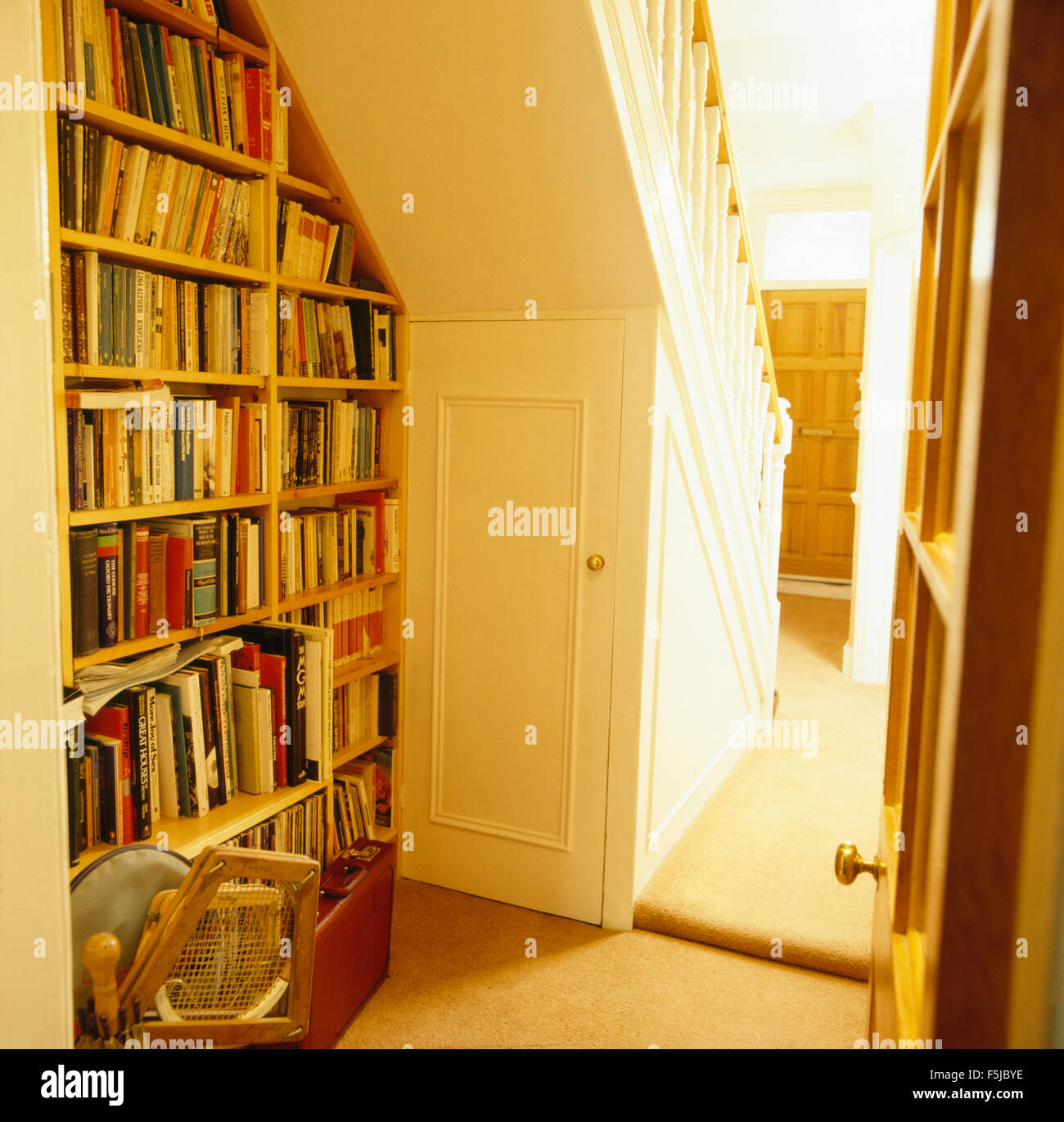Ausgestattet Bücherregalen unter Treppe in einem 80er Jahre Halle Stockfoto