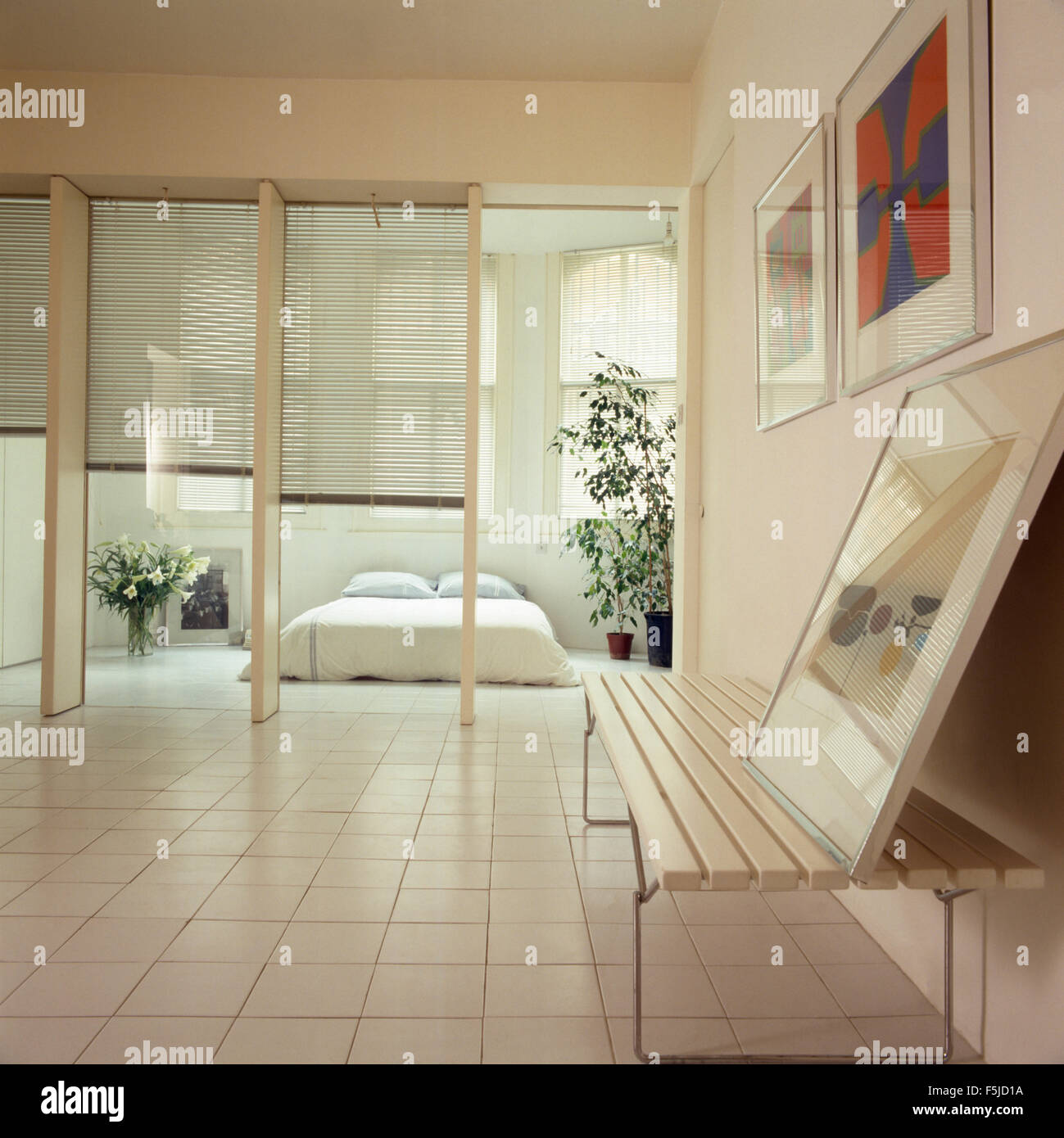 Weißer Keramik gefliesten Boden in einem 80er Jahre offen geschnittene Wohnung mit Blinds screening-Schlafzimmer Stockfoto