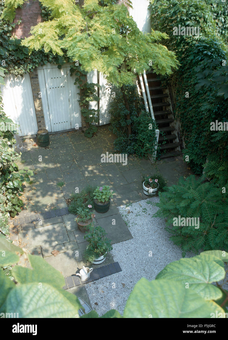 Vogelauge Ansicht von einem kleinen gepflasterten Hof mit einer hölzernen Treppe Stockfoto