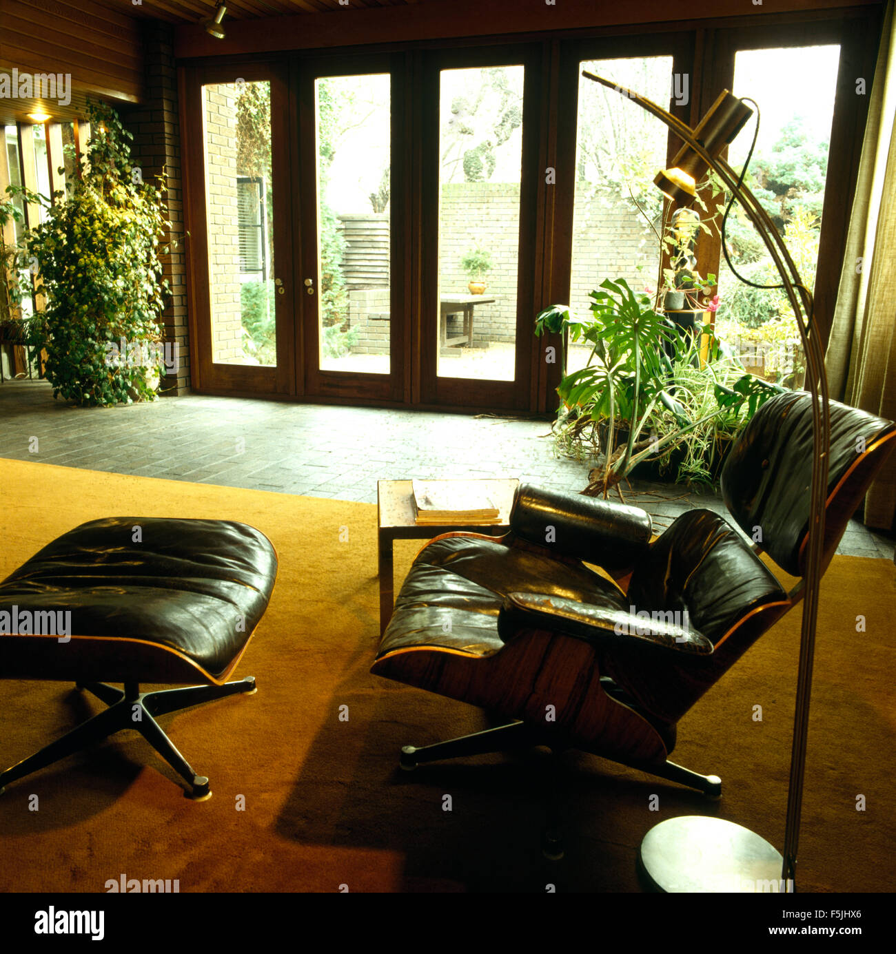 Charles Eames schwarzen Leder Sessel und Hocker in einem siebziger Jahren lebenden Raum-Erweiterung Stockfoto