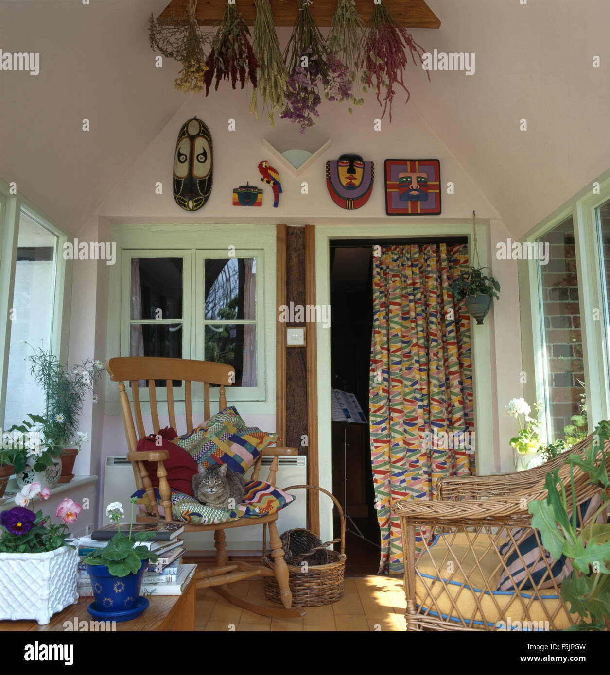 Katze sitzt auf Kiefernholz Stuhl in kleinen neunziger Jahre Wohnzimmer Stockfoto