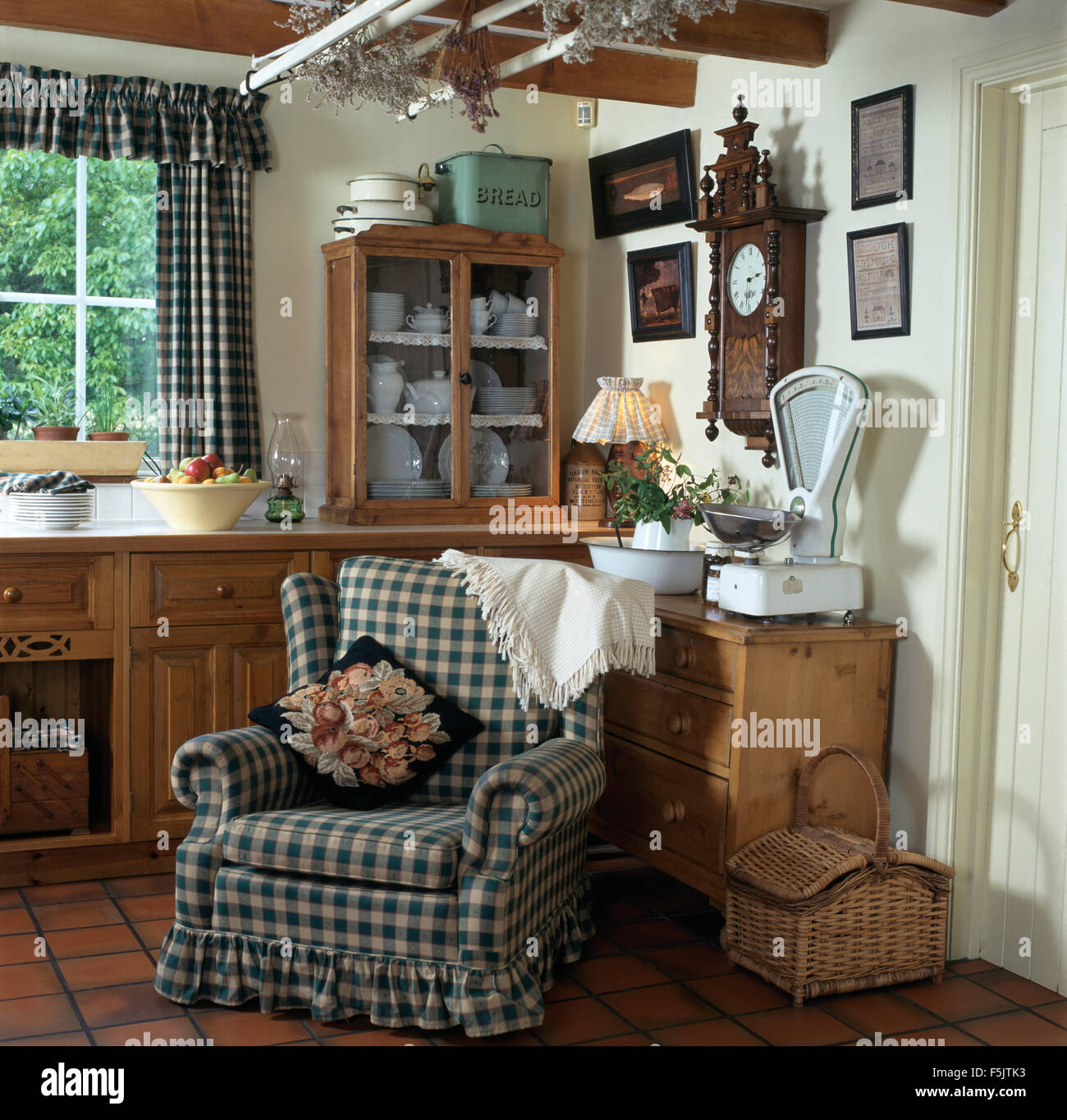 Blaue aufgegebenes lose Abdeckung auf Sessel im Cottage-Küche mit Vintage skaliert auf Kiefer Kommode Stockfoto
