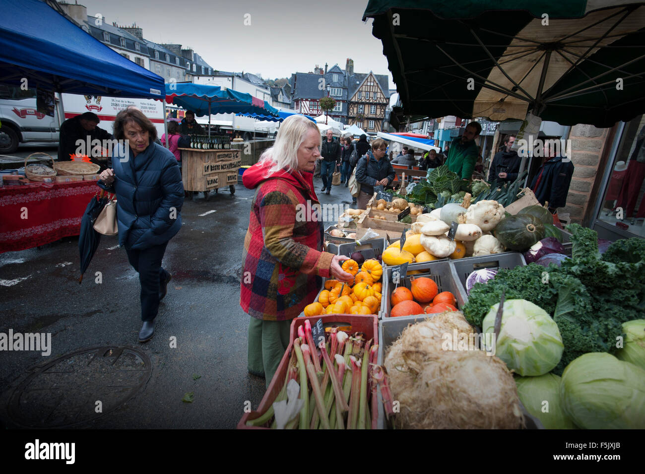 Morlaix, Bretagne, Frankreich. Der Markt und alten Gebäuden. Oktober 2015 Frau im roten Mantel-Modell veröffentlicht. Stockfoto