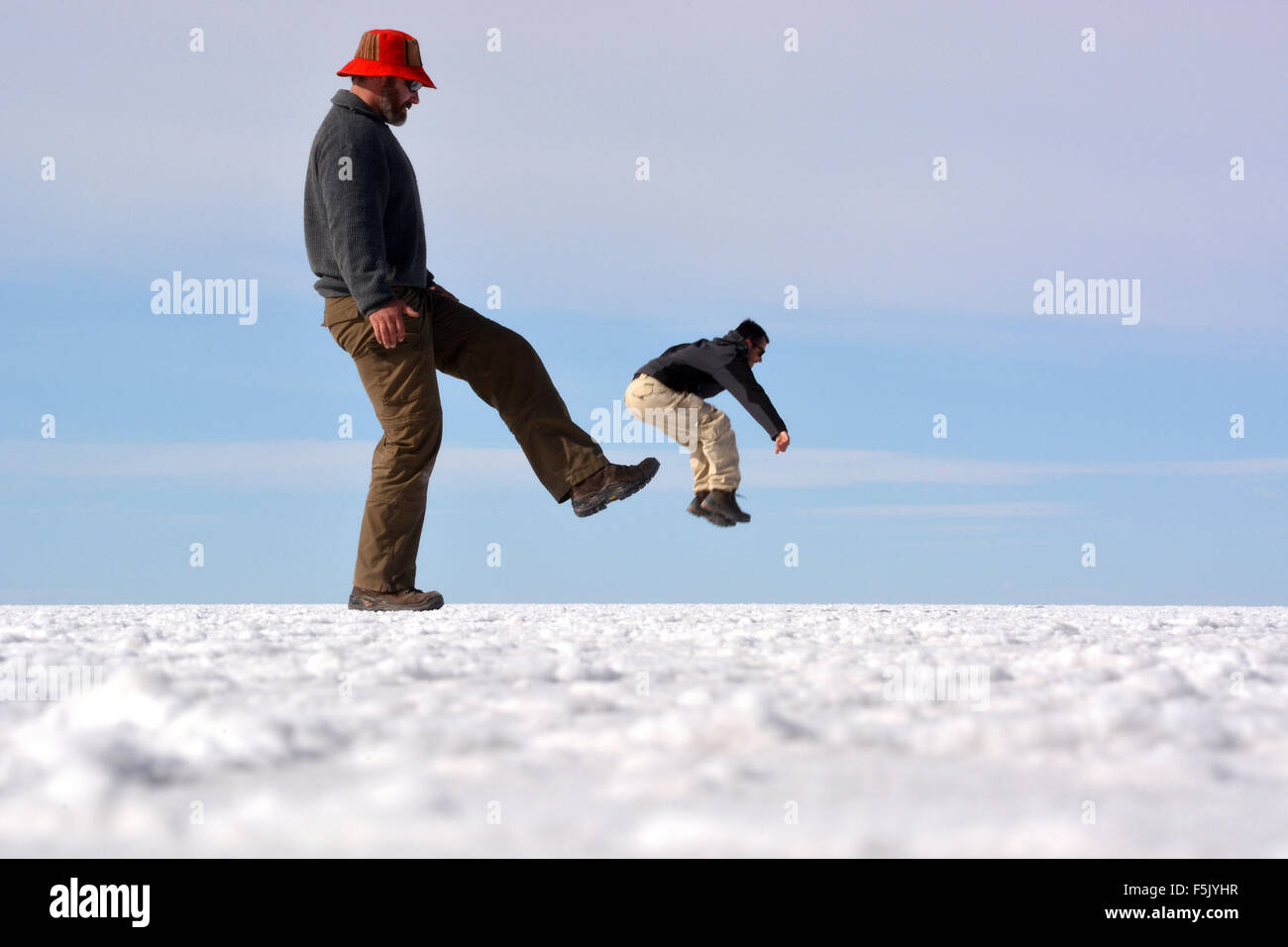 Optische Täuschung, Mann getreten werden, Salar de Uyuni, Bolivien Stockfoto