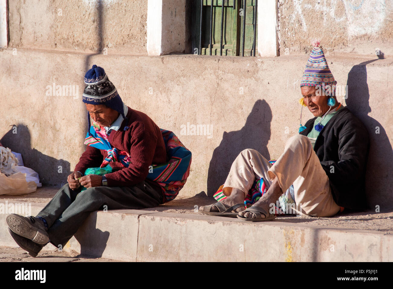 In der Regel gekleidete Männer mit Chullos, Kauen von Koka in Siesta, Colquechaca, Potosi, Bolivien Stockfoto