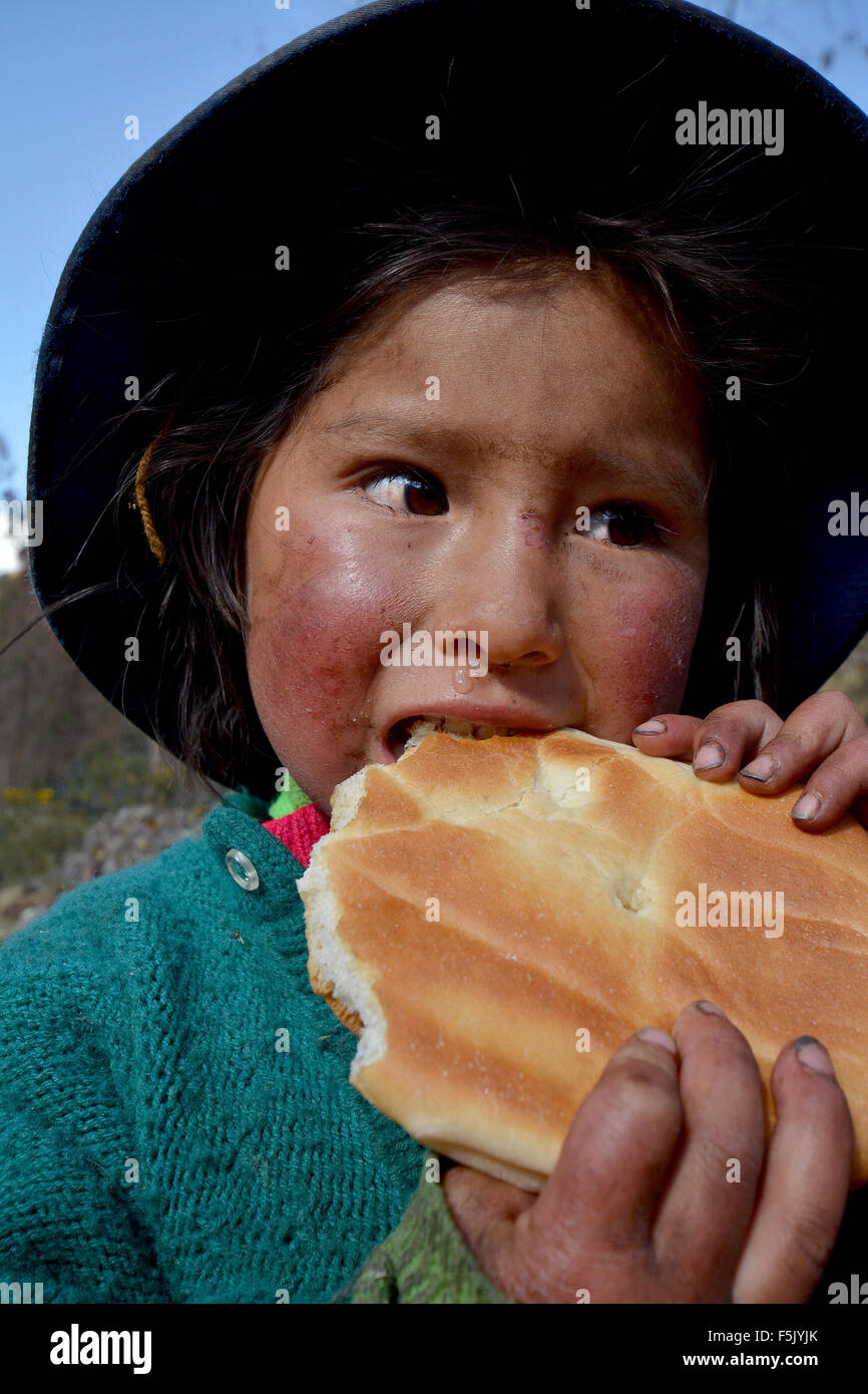 Native peruanischen Mädchen essen Brot, Porträt, Cusco, Peru Stockfoto