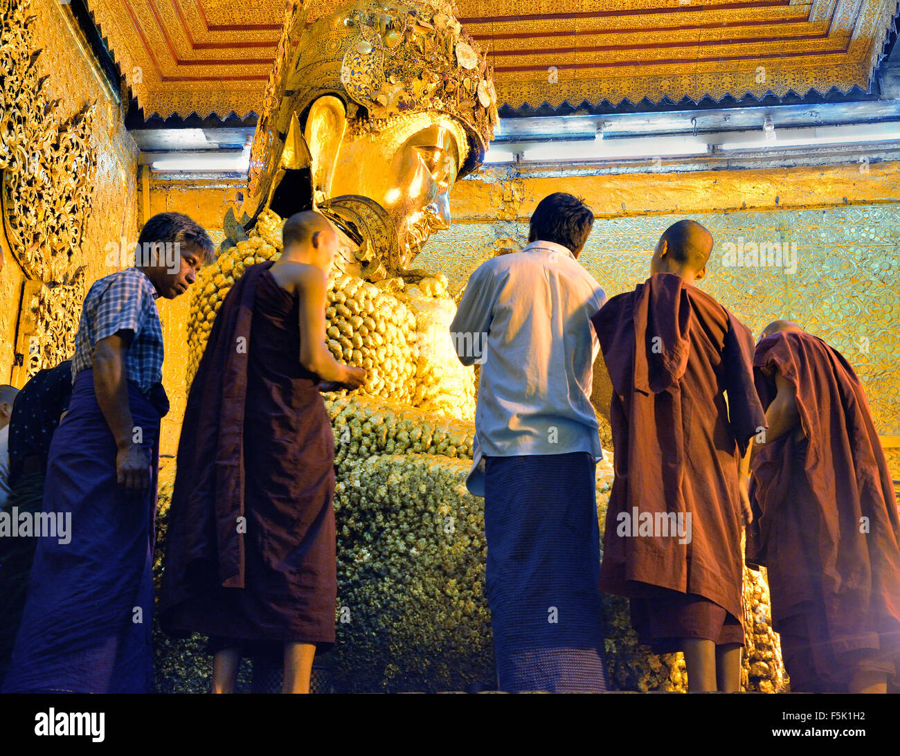 Mönche Anwendung von Blattgold auf den Mahamuni Buddha, Mandalay, Myanmar (Birma) Stockfoto