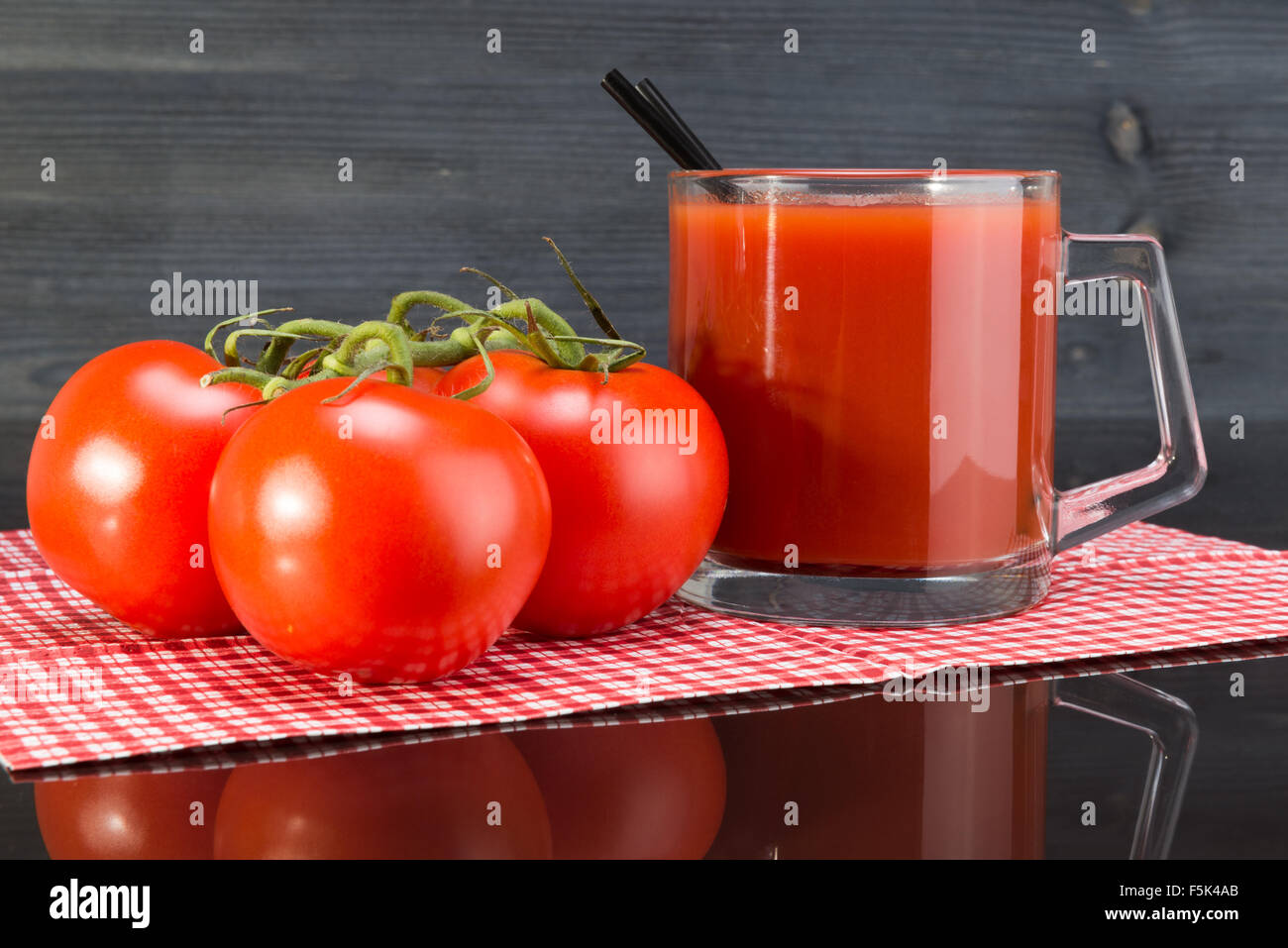 Tomatensaft, Tomaten auf einem dunklen Hintergrund Stockfoto