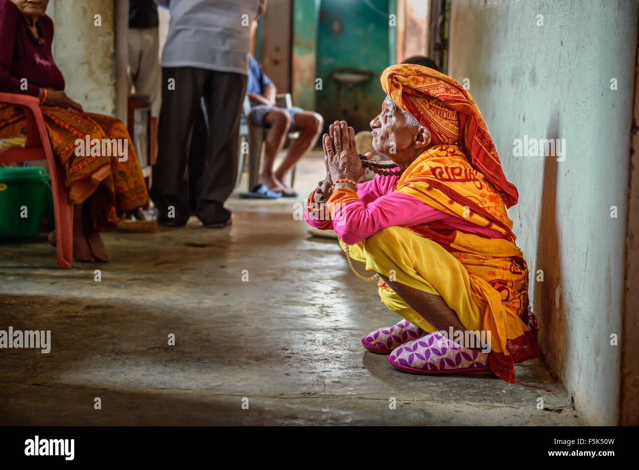 Ältere Frau betet in einem örtlichen Altersheim Stockfoto